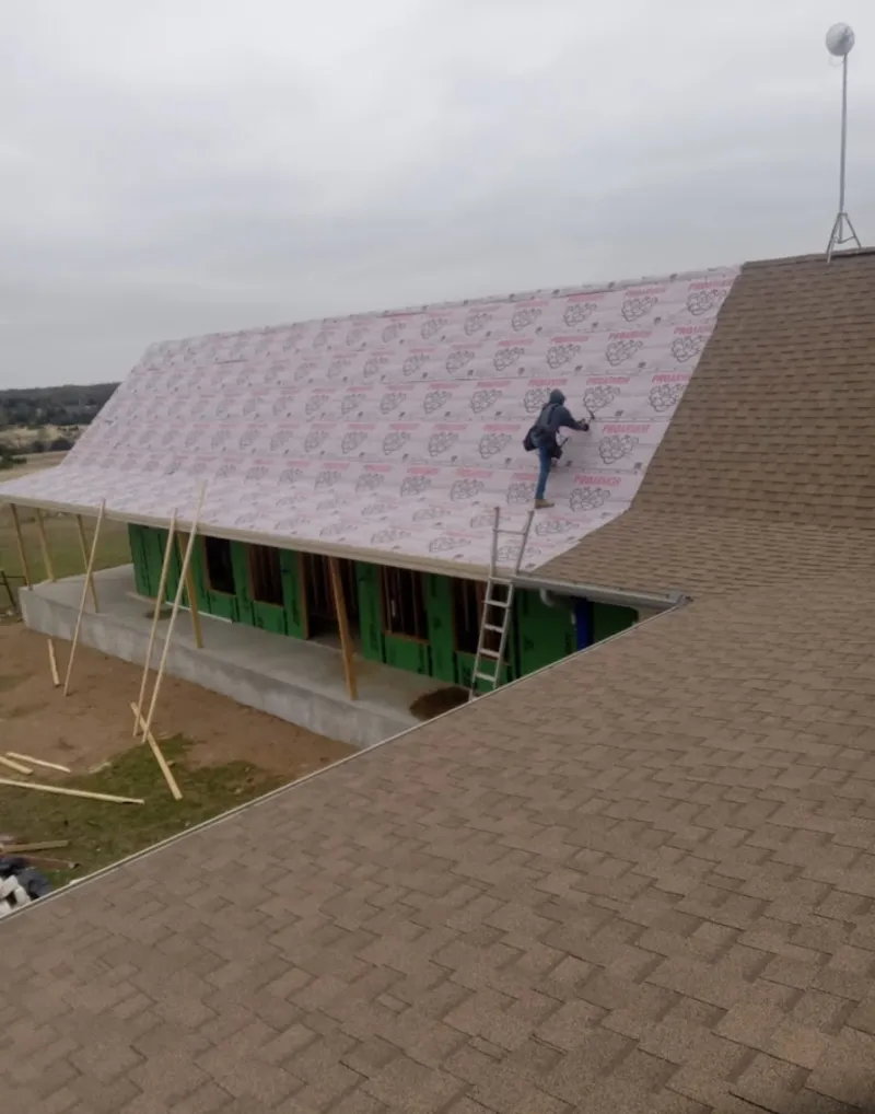 Worker preparing underlayment for a metal roof installation in Bensenville